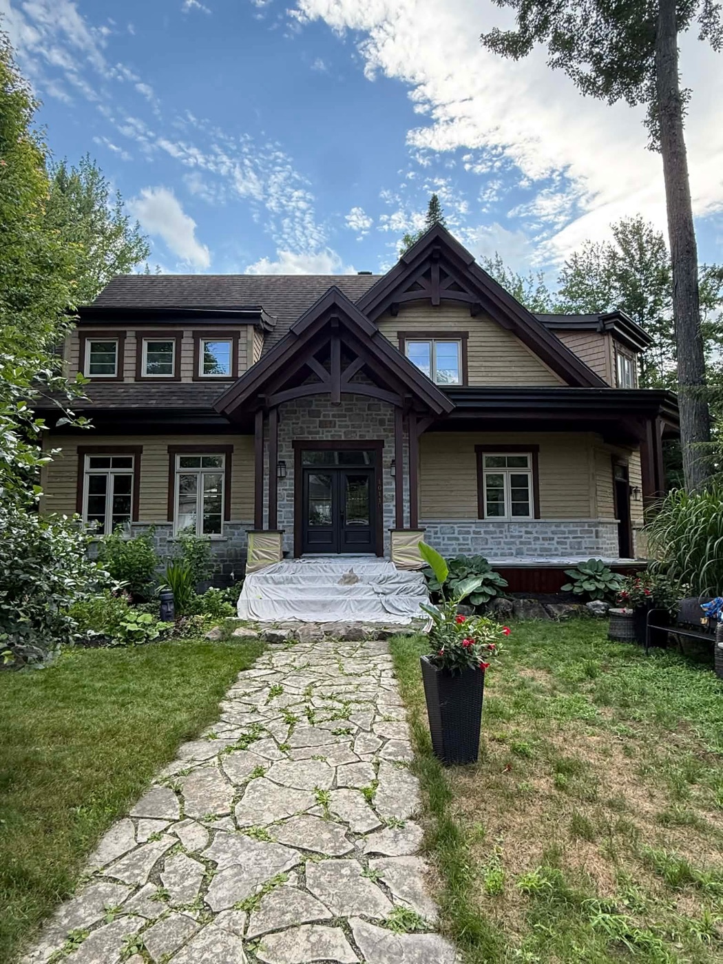 Façade avant d'une résidence de style chalet avec pierre et bois