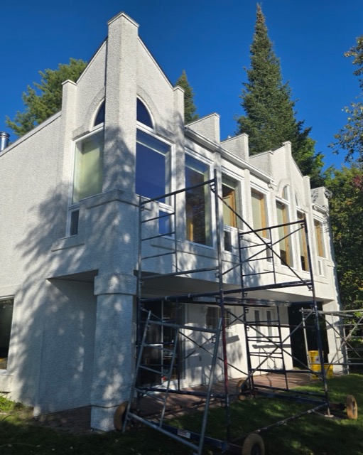 Résidence en stucco avec échafaudage avant la peinture extérieure