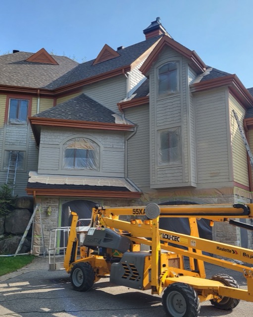 Grande résidence en travaux de peinture avec nacelle élévatrice